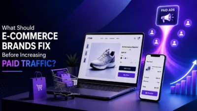 Create a professional featured image for a blog titled “What Should E-Commerce Brands Fix Before Increasing Paid Traffic?” Use a modern e-commerce and digital advertising theme with an online store, product page, shopping cart, checkout, mobile screen, and paid ads/analytics elements. Use a premium blue/purple gradient. Keep it minimal, clean, and high quality (1200x630). Place the provided logo in a corner exactly as given, without any changes, cropping, recoloring, or redesign.